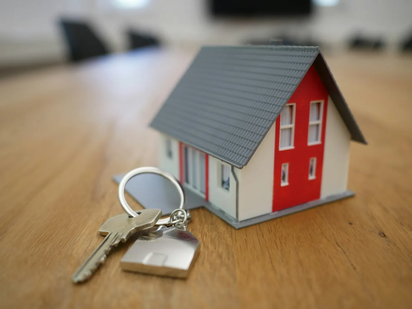 Adjudicação compulsória: chaves e miniatura de casa sobre a mesa